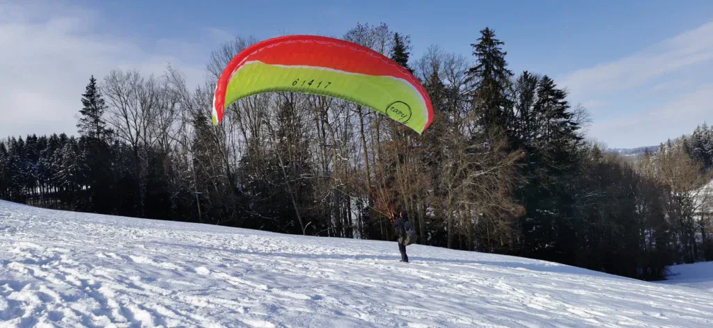 Start mit dem Gleitschirm am Übungshang im Winter
